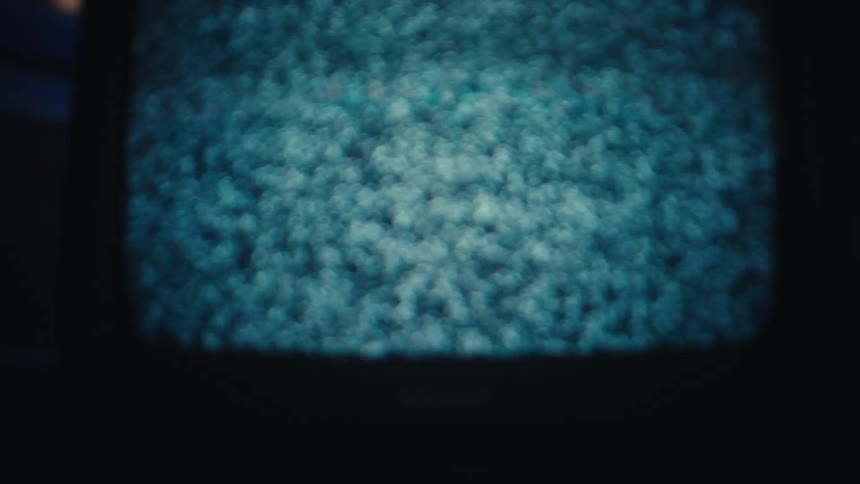 Television shows static noise on a curved screen with blue ambient lighting
