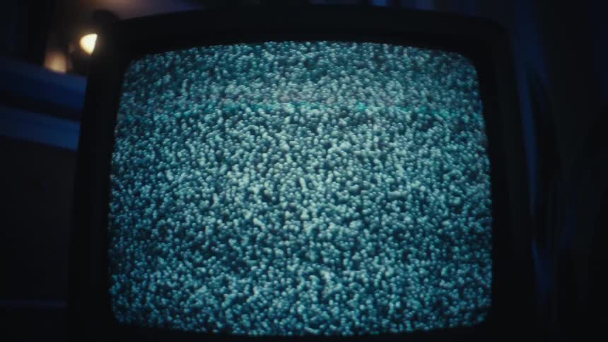 Television displays static noise in an indoor setting with bluetoned lighting