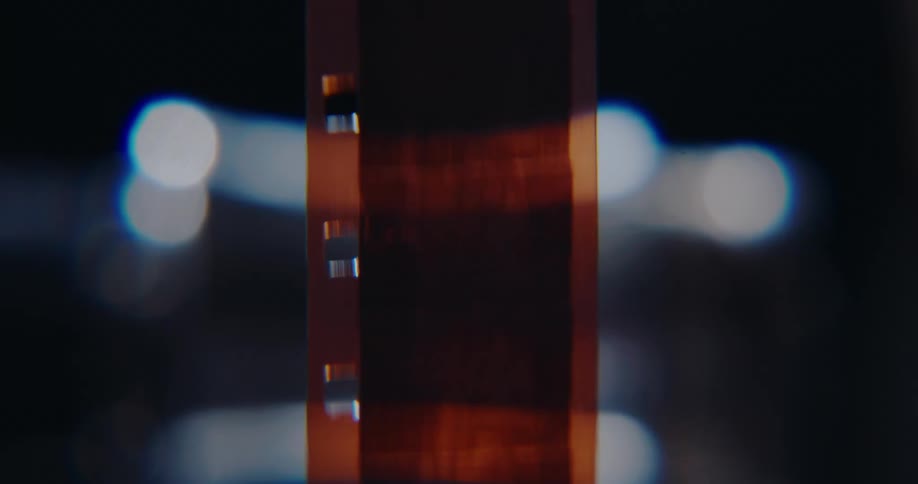 Backlit vertical film strip with perforations along the edges