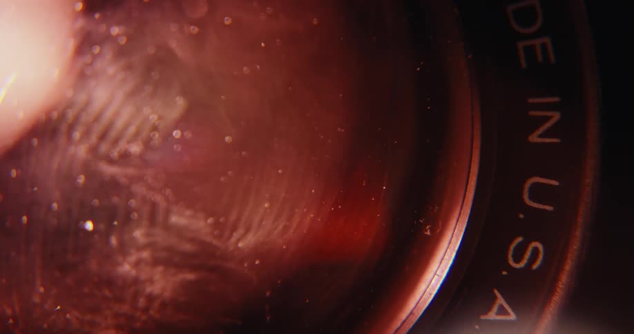Flickering lights over the lens of a vintage super 8mm camera indoors