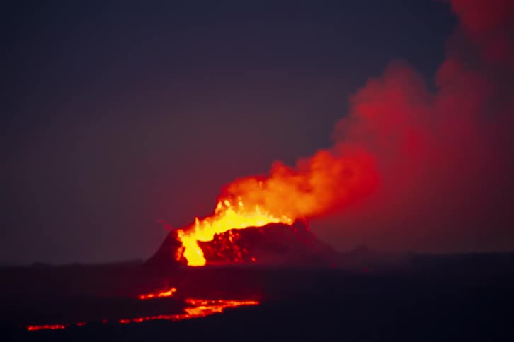 A view of a small volcano with lava coming out of it
