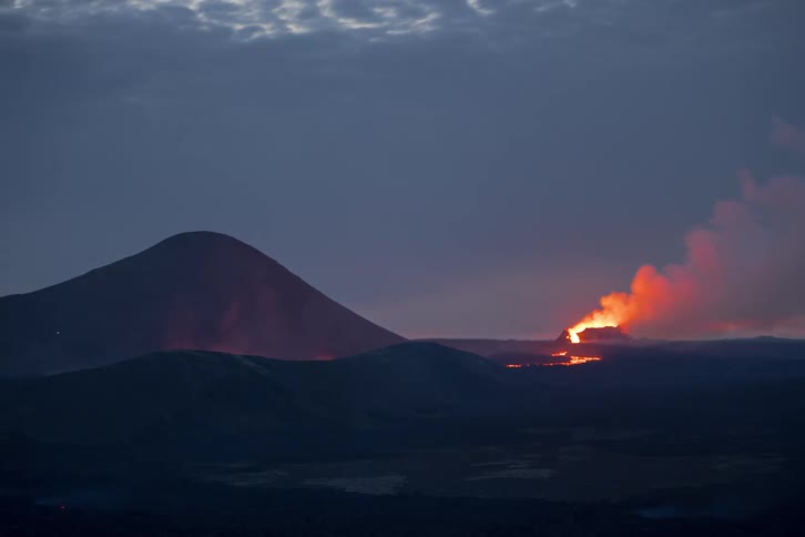 Volcanic eruption with glowing lava and smoke plumes at dusk