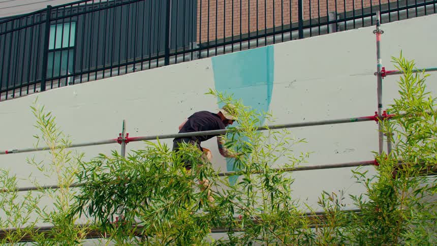 A man painting a wall outdoors