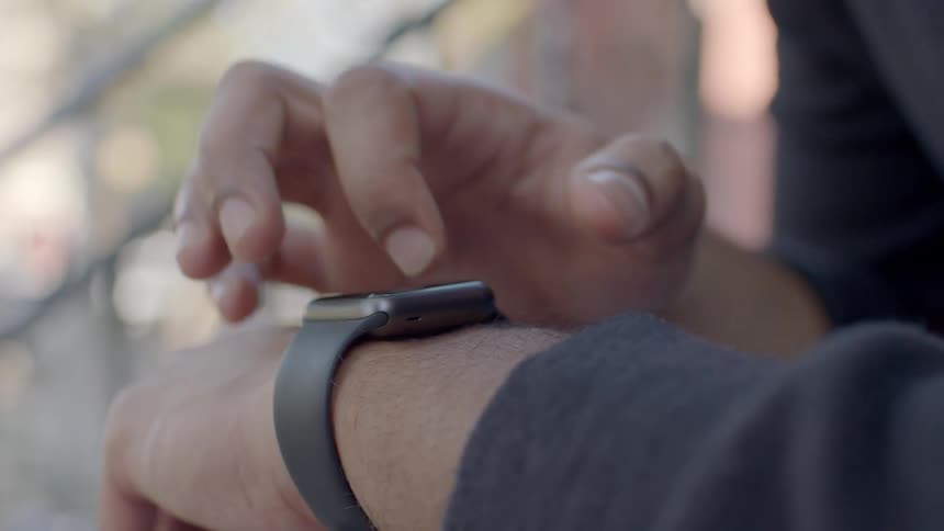 A man taps on his smart watch