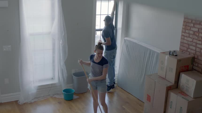 Man and woman clean a house before moving into it