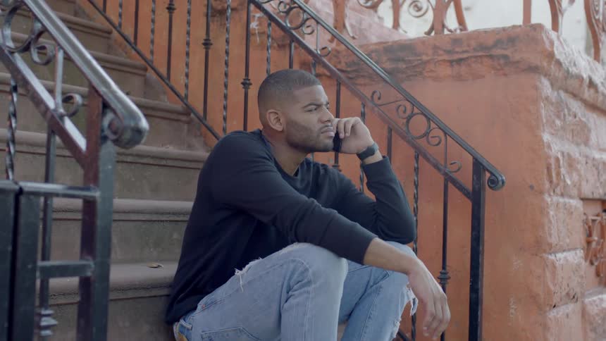 A man sits on the steps and uses his phone