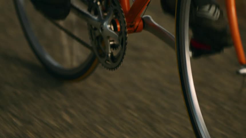 Closeup of cyclists foot on orange bike pedal in motion with focus on mechanics