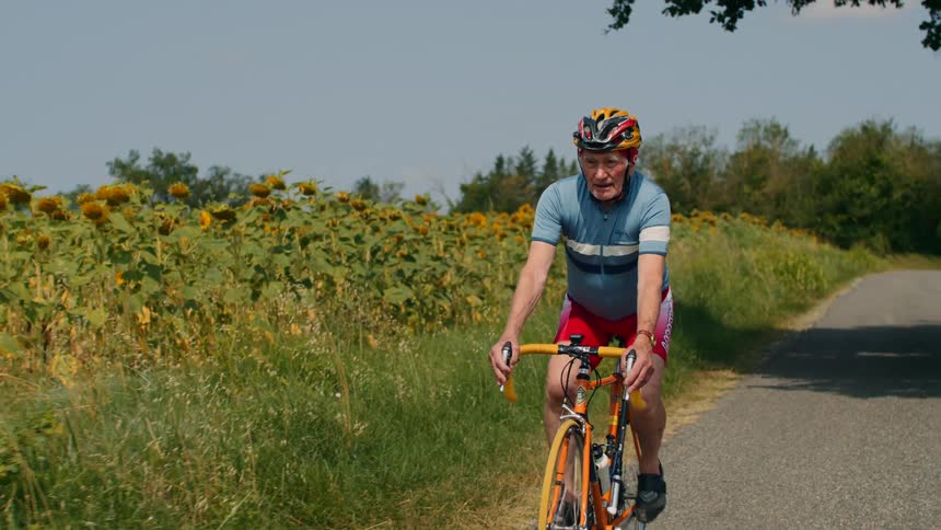 A man riding a bicycle outdoors on a sunny day