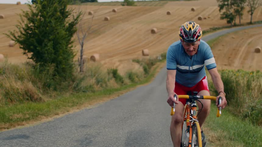 The man is cycling on the trail