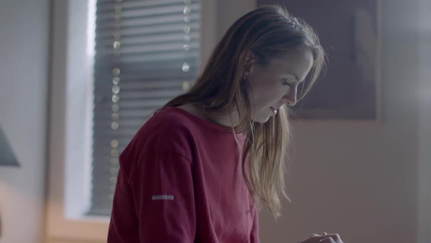 A woman uses a tablet in bed