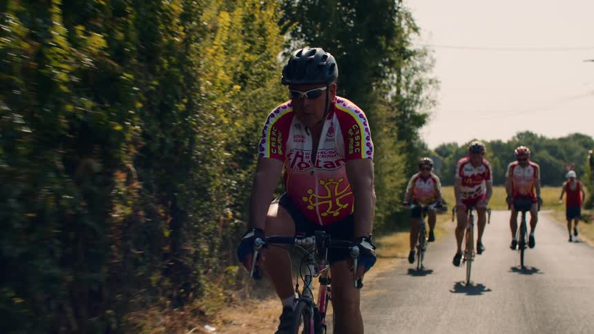The men are racing on their bicycles