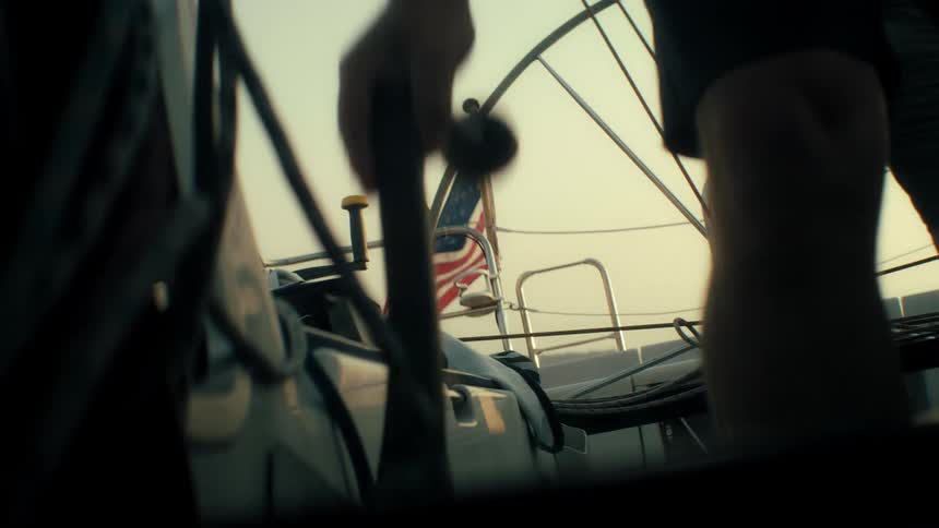 Nautical scene with two people on boat american flag in background and soft daylight