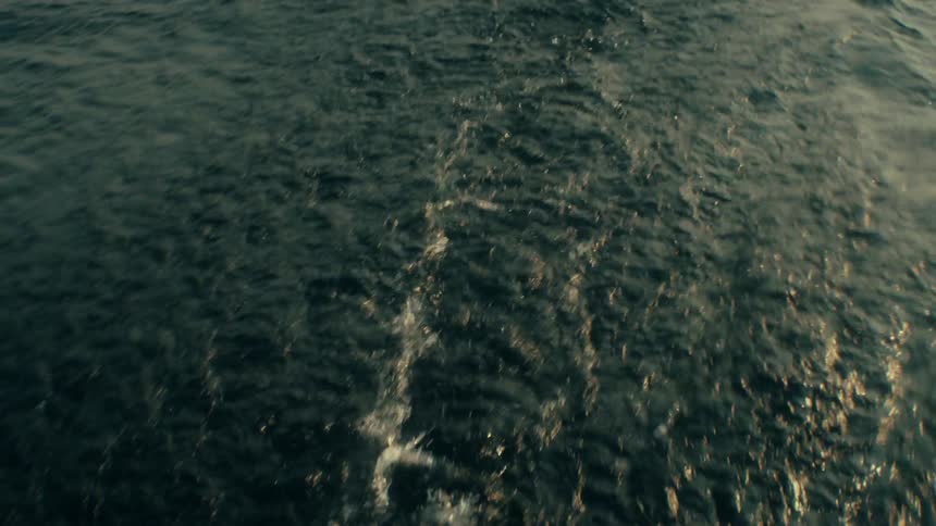 Wake left by a watercraft disturbs the surface of the water during the daytime