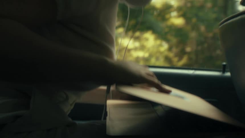 Person working on laptop in backseat of moving vehicle