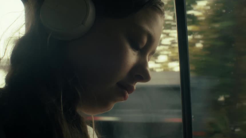 Girl with headphones on inside a car