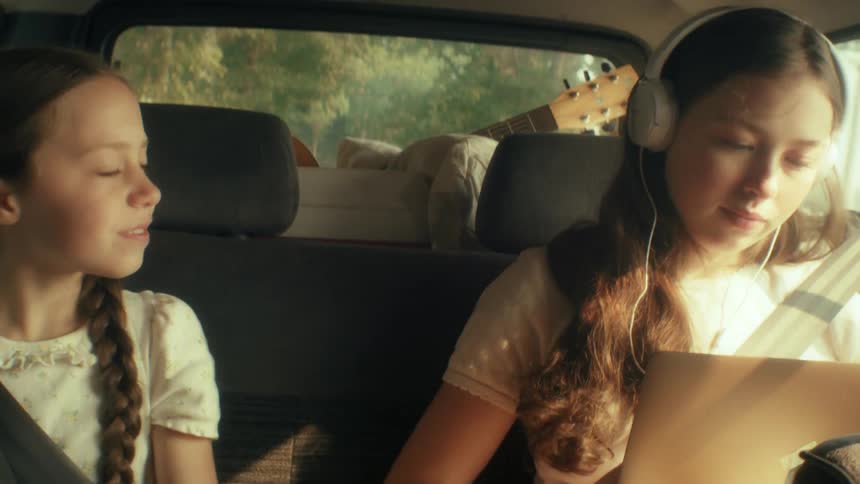 Girls talk while riding in the backseat of the car