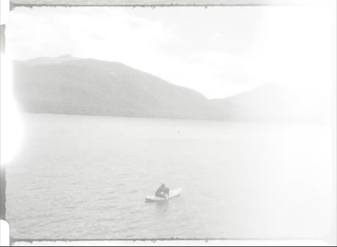 People are rowing in the lake on a canoe