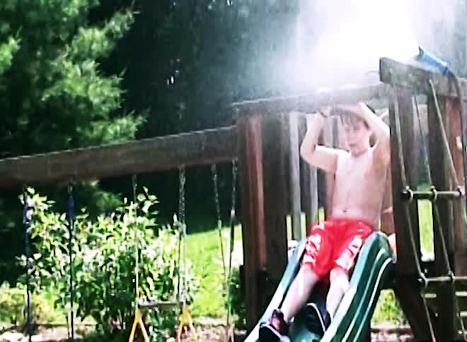 Boy slipping and falling into an inflatable pool