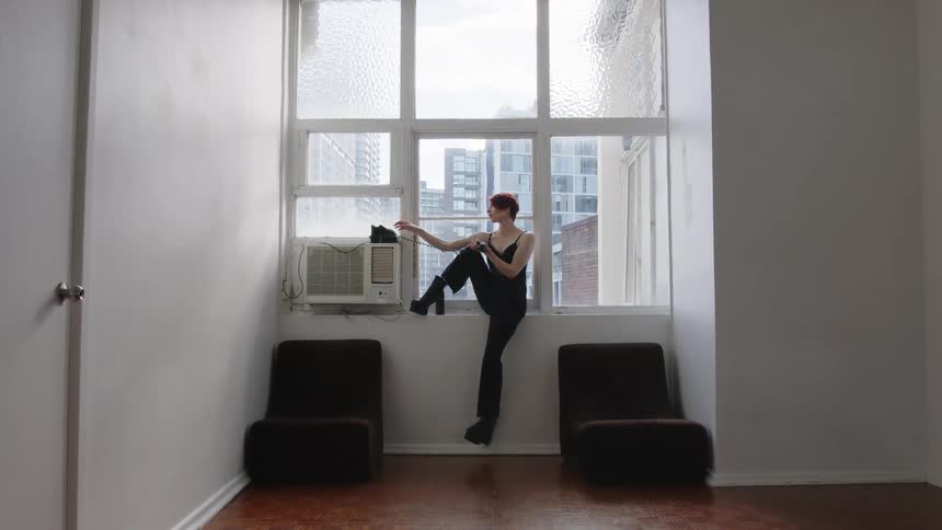 A woman sitting in front of a window