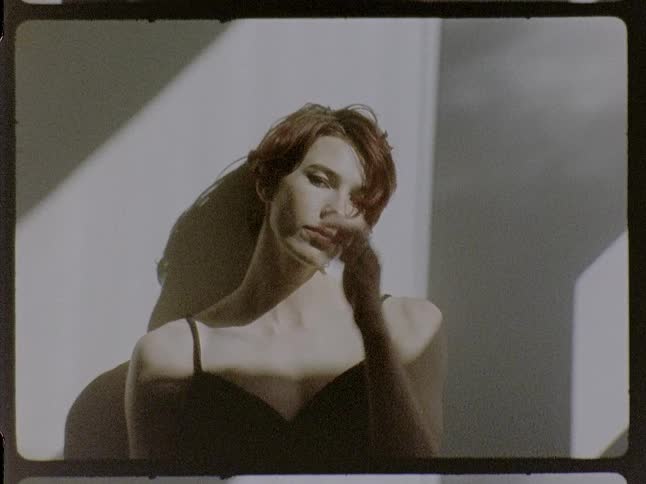 A woman poses confidently against a minimalist backdrop in a bold fashion portrait