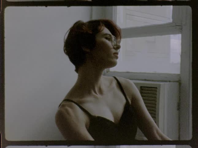 A woman standing in a room in front of a window