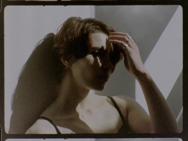 Woman touches the side of her head under natural light indoors