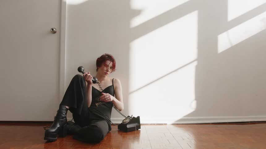 A woman using an old phone in a room