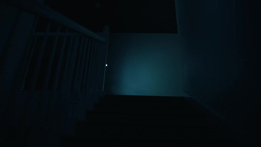 A person wearing a dark outfit and a headlamp walks down a dark staircase while holding a flashlight to illuminate the way