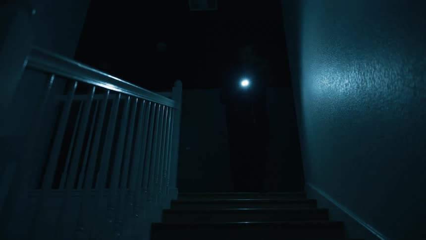 Person with a flashlight walking on an internal staircase