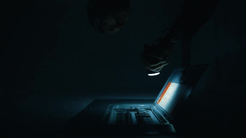 A man with a flashlight opens up a breaker box during a power outage
