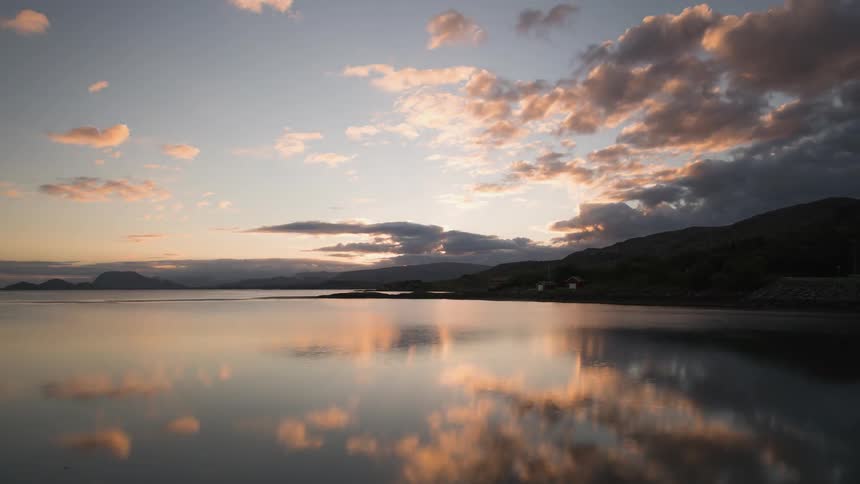 Morning clouds at sunrise reflected off a fjord in Norway
