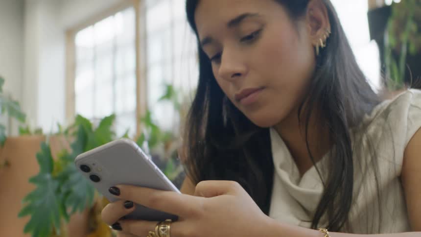 Teenage girl sitting at a desk texting on her phone