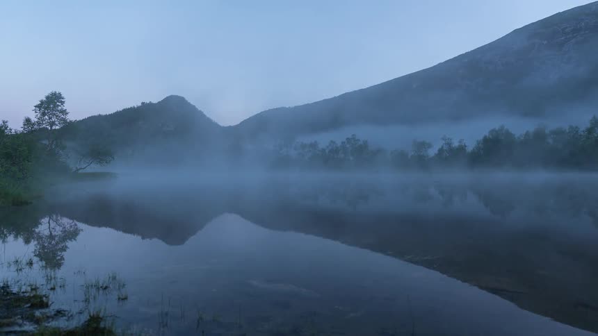 The early morning fog is rolling around on the lake