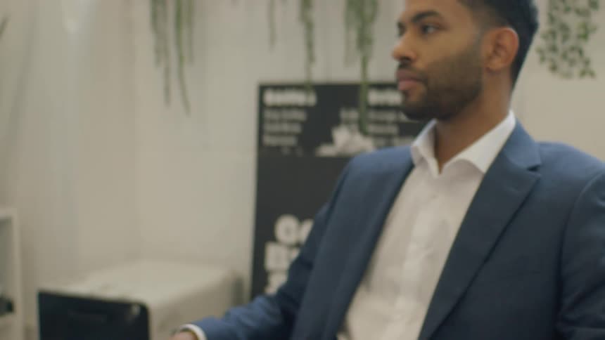 Man drops a document looking upset while sitting back in his chair in the office