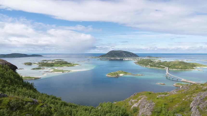 Clouds pass over sea with islands connected by bridge