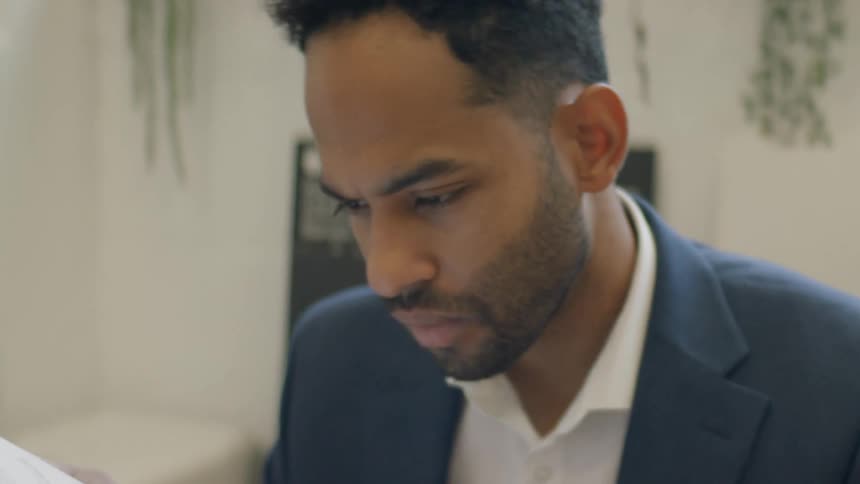The man reads paperwork in the office