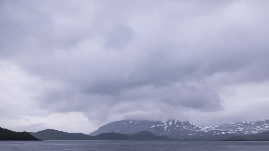 Time-lapse of stormy clouds moving over a lake