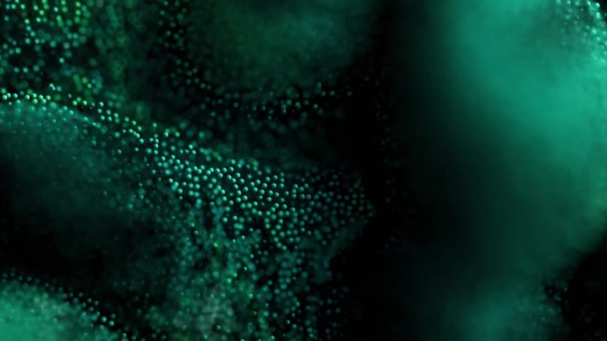 An abstract animation of small glowing green particles that move and flow in waves across a dark background