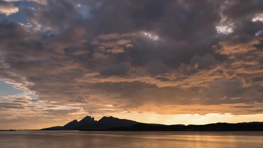 Heavy sunset clouds move over this coastline at dawn