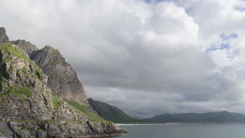 Clouds pass by above a lake and a mountain