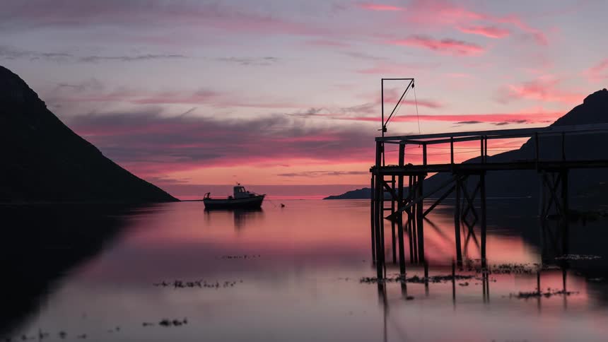 An anchored boat moves with the tide at sunset