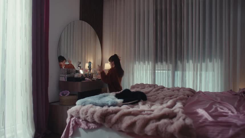 The woman films herself talking in front of a mirror on her cell phone