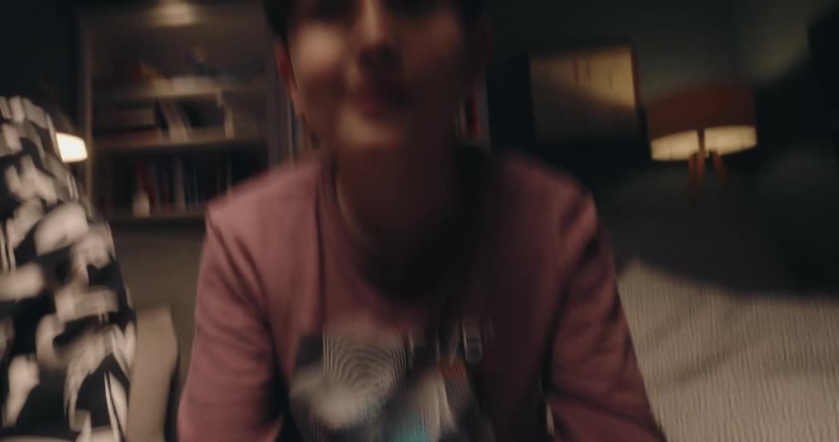A young boy sits on a couch intently gripping a gaming controller and moving his thumbs across the joystickshe then looks up toward the screen with a slight smile and a focused expression appearing immersed in his gameplay