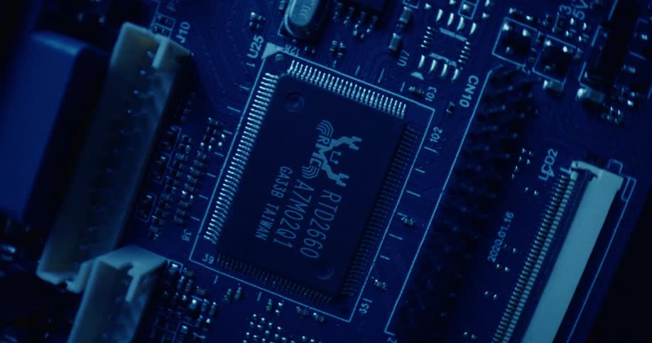 A closeup topdown view of a blue circuit board with a realtek rtd2660 chip as the central focusthe camera slowly rotates around the processor revealing intricate copper traces and various surfacemounted components under atmospheric blue lighting