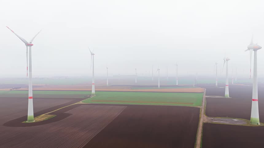 A view of some power generating windmills on a cloudy day