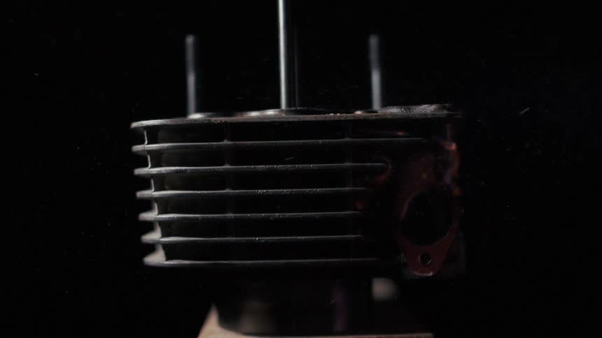 Intense flames surround a metal engine component in an industrial environment
