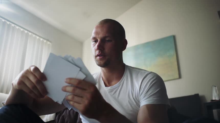 A man reads some mail in his hands