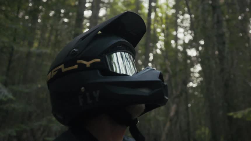 Male motorcyclist sits on his motorcycle in the forest on an autumn day