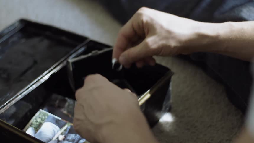 A man looks at an engagement ring and closes it in a box