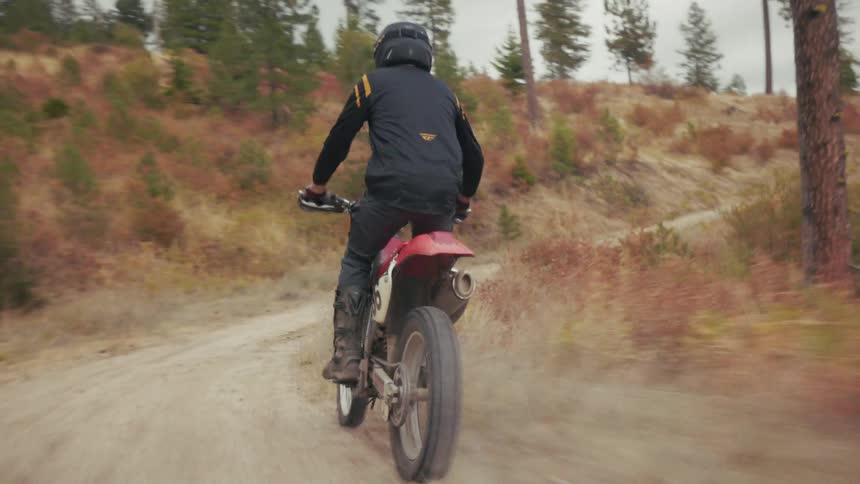The dirt bike speeds and turns on the long trail
